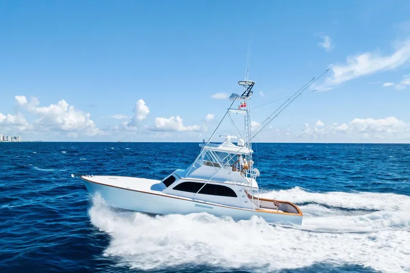 Nic-nac Yacht Photos Pics 1977 Merritt Sportfish yacht cruising on open ocean under clear blue sky.