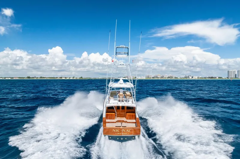 Nic-nac Yacht Photos Pics 1977 Merritt Sportfish yacht cruising on open ocean under clear blue sky.