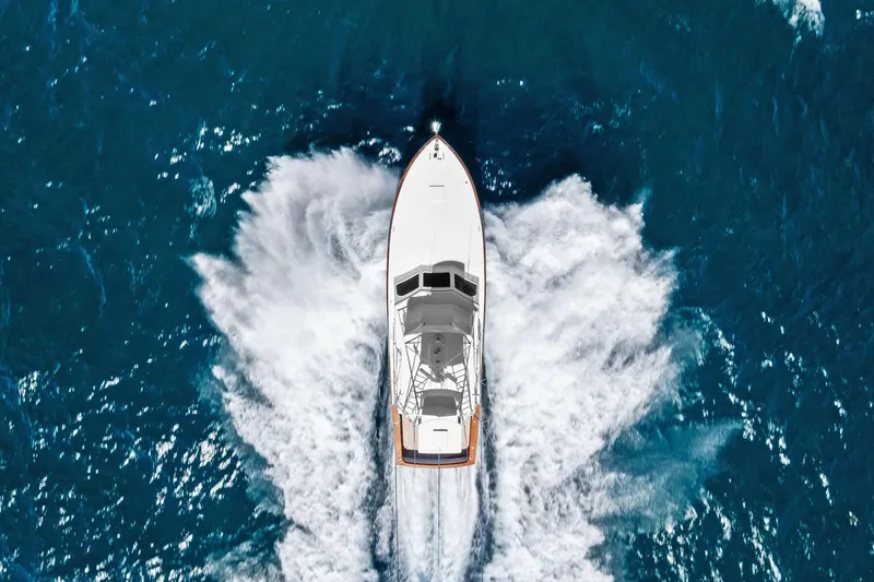 Nic-nac Yacht Photos Pics Aerial view of 1977 Merritt Sportfish boat cruising through blue ocean waters.