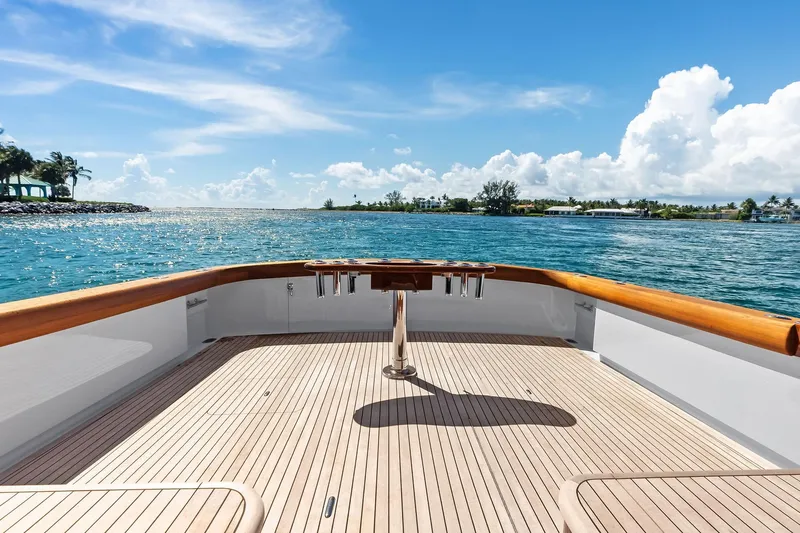 Nic-nac Yacht Photos Pics 1977 Merritt Sportfish boat deck with ocean view, clear skies, and wooden railings.