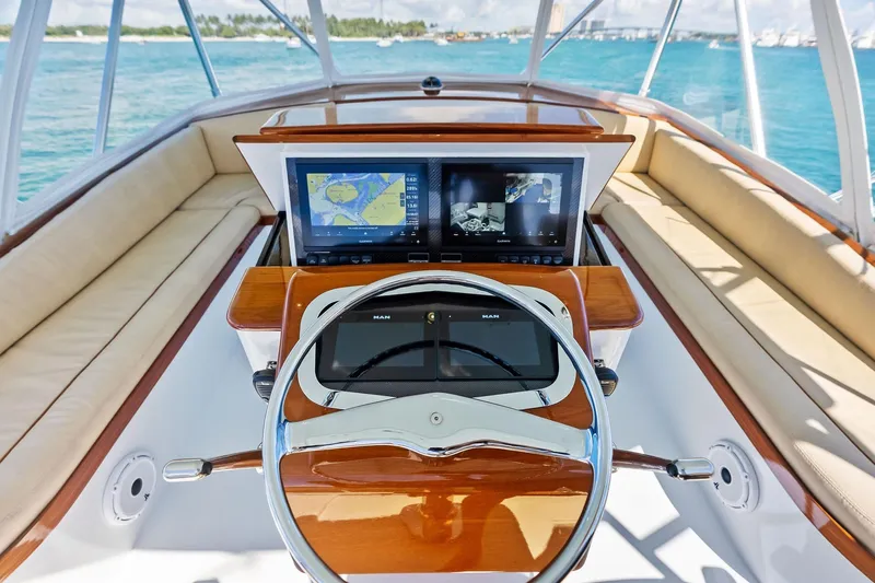 Nic-nac Yacht Photos Pics 1977 Merritt Sportfish helm with modern navigation screens and luxurious seating, overlooking blue waters.