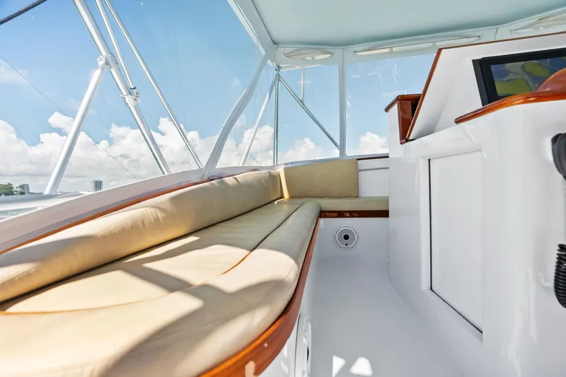 Nic-nac Yacht Photos Pics Interior of a 1977 Merritt Sportfish boat with cushioned seating and clear windows.