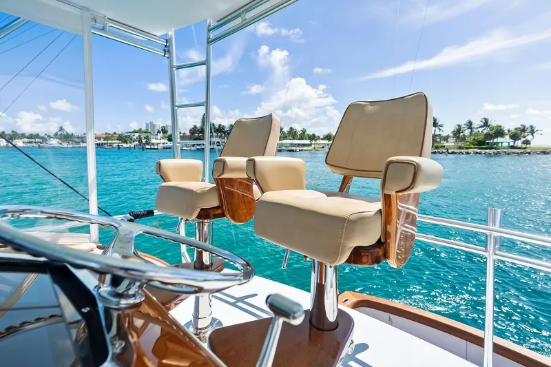 Nic-nac Yacht Photos Pics Captain's chairs on 1977 Merritt Sportfish yacht, overlooking turquoise waters and clear skies.
