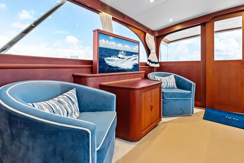 Nic-nac Yacht Photos Pics Luxurious 1977 Merritt Sportfish yacht interior with blue chairs and wooden accents.