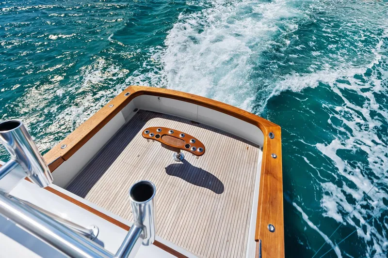 Nic-nac Yacht Photos Pics 1977 Merritt Sportfish boat deck with wooden trim cruising on blue ocean waters.