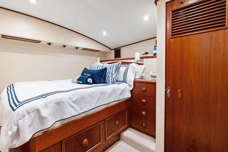 Nic-nac Yacht Photos Pics Luxurious cabin interior of 1977 Merritt Sportfish yacht with cozy bed and wooden cabinetry.