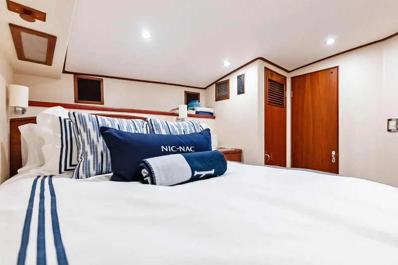 Nic-nac Yacht Photos Pics Cozy cabin interior of 1977 Merritt Sportfish yacht with elegant bedding and wooden accents.