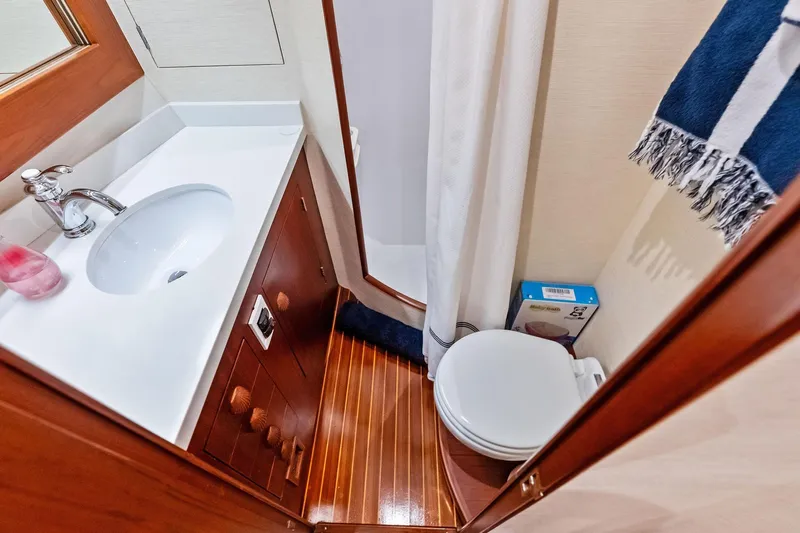 Nic-nac Yacht Photos Pics 1977 Merritt Sportfish bathroom with wooden flooring, sink, and toilet.