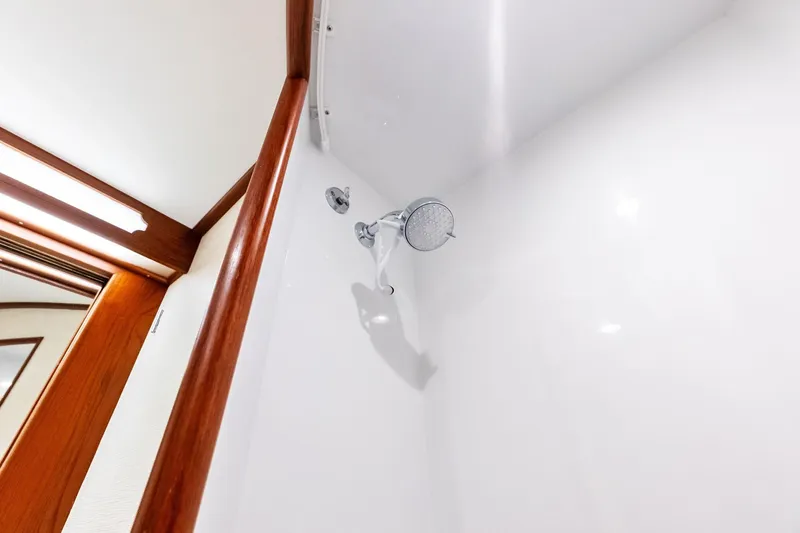 Nic-nac Yacht Photos Pics Shower area in 1977 Merritt Sportfish boat with wooden trim and modern fixtures.