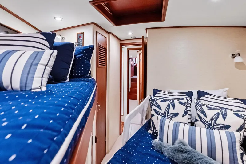 Nic-nac Yacht Photos Pics Interior of 1977 Merritt Sportfish yacht with nautical-themed bedding and cozy cabin design.