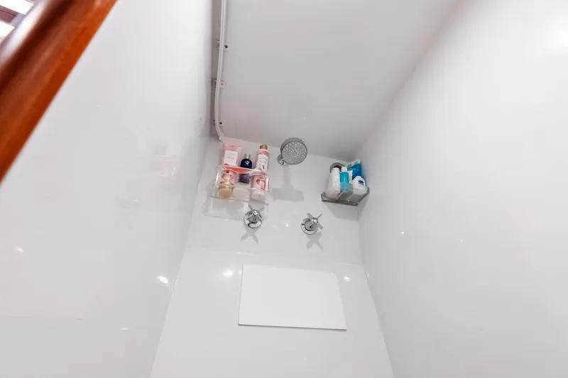 Nic-nac Yacht Photos Pics Shower area in a 1977 Merritt Sportfish boat with toiletries and showerhead.