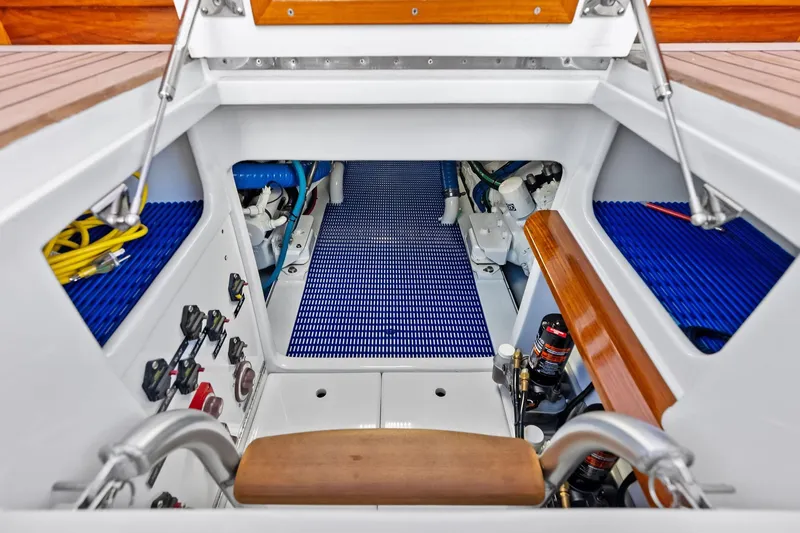 Nic-nac Yacht Photos Pics Engine room of a 1977 Merritt Sportfish boat with blue flooring and control panels.