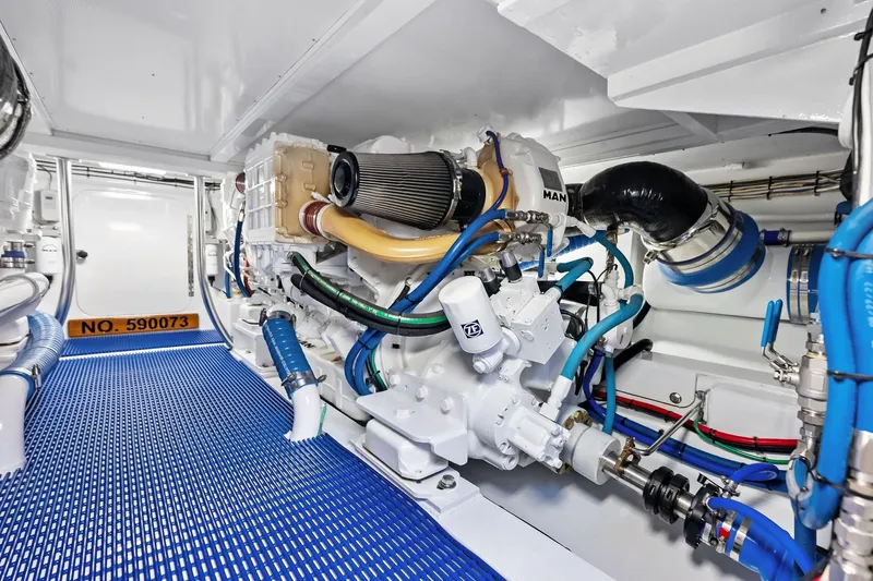 Nic-nac Yacht Photos Pics Engine room of a 1977 Merritt Sportfish boat with modern equipment and blue flooring.