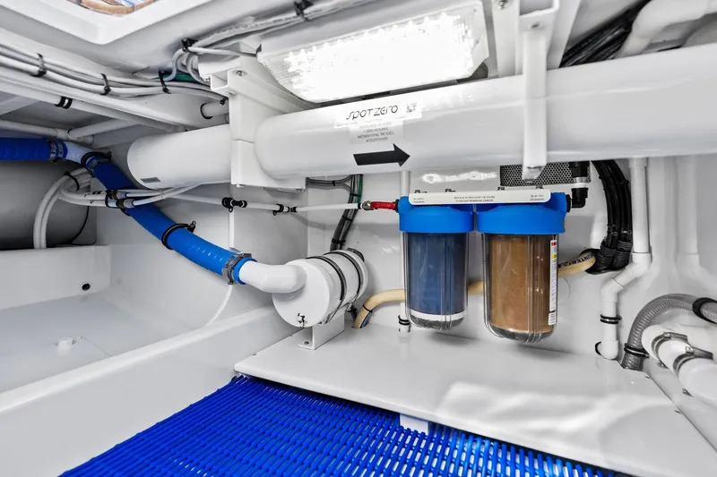 Nic-nac Yacht Photos Pics Engine room of a 1977 Merritt Sportfish boat with filtration system and blue hoses.