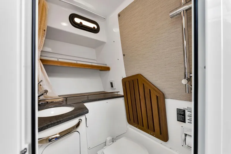  Yacht Photos Pics 2023 Boston Whaler 350 Realm boat bathroom with modern fixtures and wood accents.