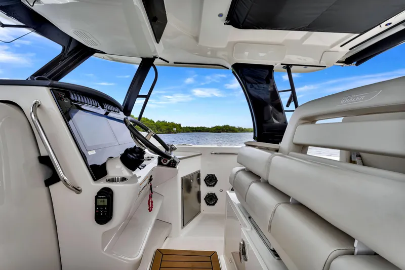 Yacht Photos Pics Interior view of 2023 Boston Whaler 350 Realm boat, featuring helm and seating area.