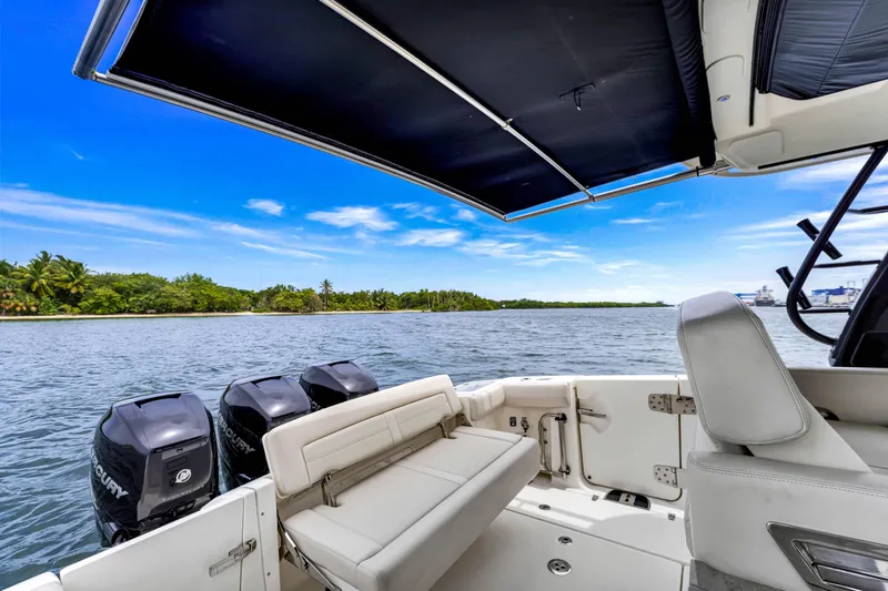  Yacht Photos Pics 2023 Boston Whaler 350 Realm boat with triple Mercury engines on a scenic waterway.