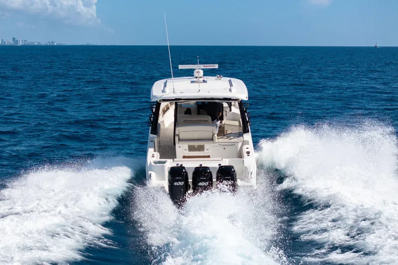  Yacht Photos Pics 2023 Boston Whaler 350 Realm cruising on open ocean, rear view with powerful engines.