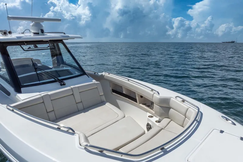  Yacht Photos Pics 2023 Boston Whaler 350 Realm boat on open sea with luxurious seating and clear skies.