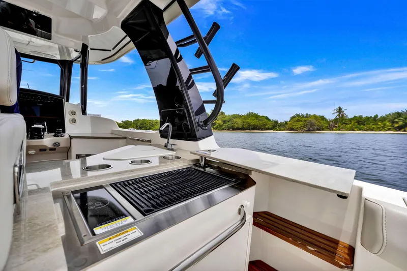  Yacht Photos Pics 2023 Boston Whaler 350 Realm boat interior with grill, overlooking tropical waters.