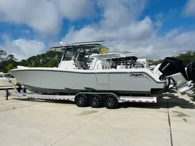  Yacht Photos Pics 2020 Invincible 37' Catamaran on trailer, docked at marina under blue sky.