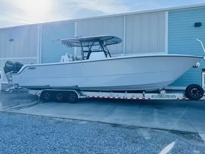  Yacht Photos Pics 2020 Invincible 37' Catamaran on a trailer outside a blue building.