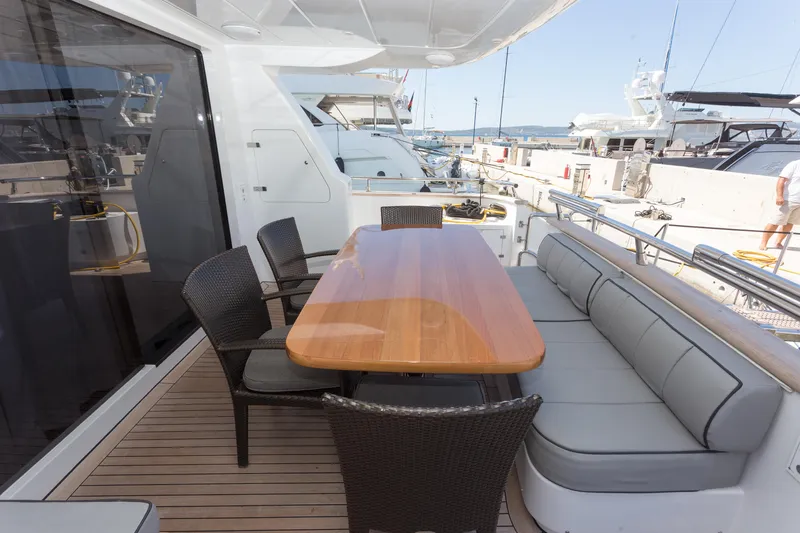  Yacht Photos Pics Outdoor dining area on 2008 Maiora 20S yacht with wooden table and cushioned seating.