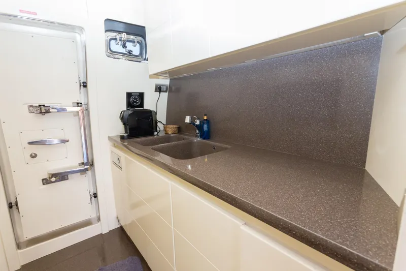  Yacht Photos Pics Compact kitchen area in a 2008 Maiora 20S yacht with modern appliances and sleek countertops.