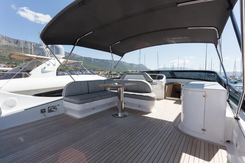  Yacht Photos Pics Luxurious 2008 Maiora 20S yacht deck with seating, table, and canopy in marina setting.