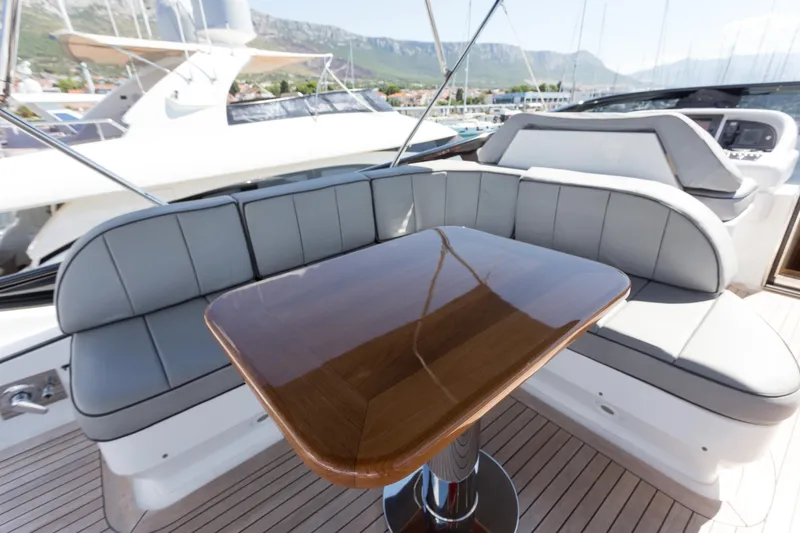  Yacht Photos Pics Luxurious seating area on a 2008 Maiora 20S yacht with polished wooden table.