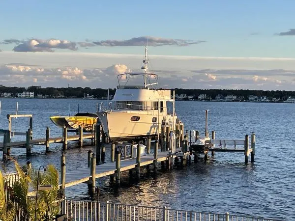  Yacht Photos Pics 2019 Beneteau Swift Trawler 44 docked on a serene waterfront at sunset.