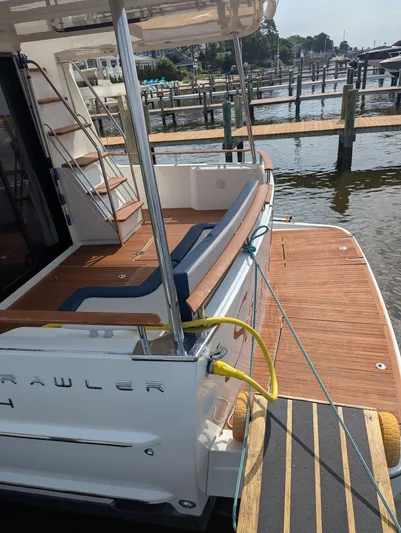  Yacht Photos Pics 2019 Beneteau Swift Trawler 44 docked, showcasing elegant wooden deck and seating area.
