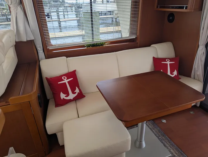  Yacht Photos Pics Interior of 2019 Beneteau Swift Trawler 44 with anchor-themed cushions and wooden table.