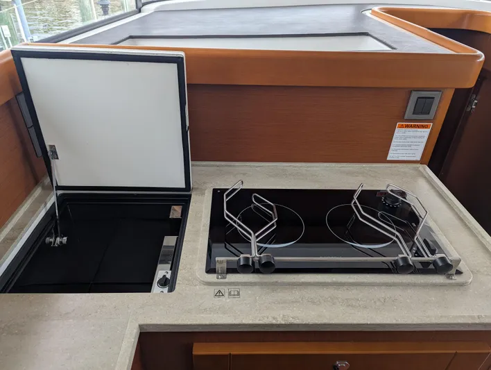  Yacht Photos Pics 2019 Beneteau Swift Trawler 44 kitchen with stove and storage compartment.