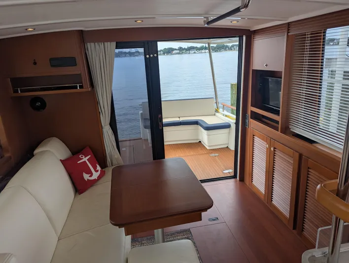  Yacht Photos Pics Interior of 2019 Beneteau Swift Trawler 44 with elegant seating and scenic water view.