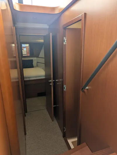  Yacht Photos Pics Interior hallway of 2019 Beneteau Swift Trawler 44, featuring wood paneling and bedroom view.