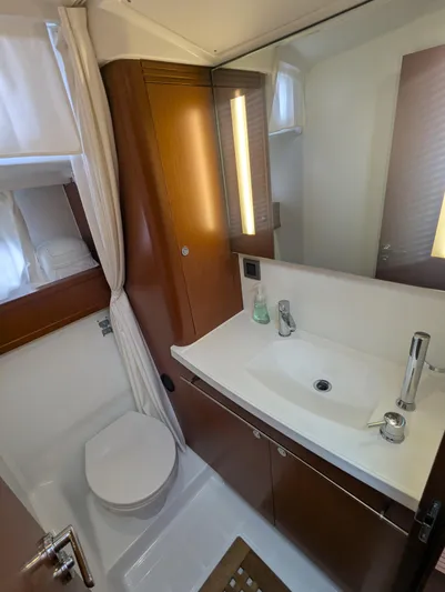  Yacht Photos Pics 2019 Beneteau Swift Trawler 44 bathroom with modern sink, mirror, and wooden cabinetry.