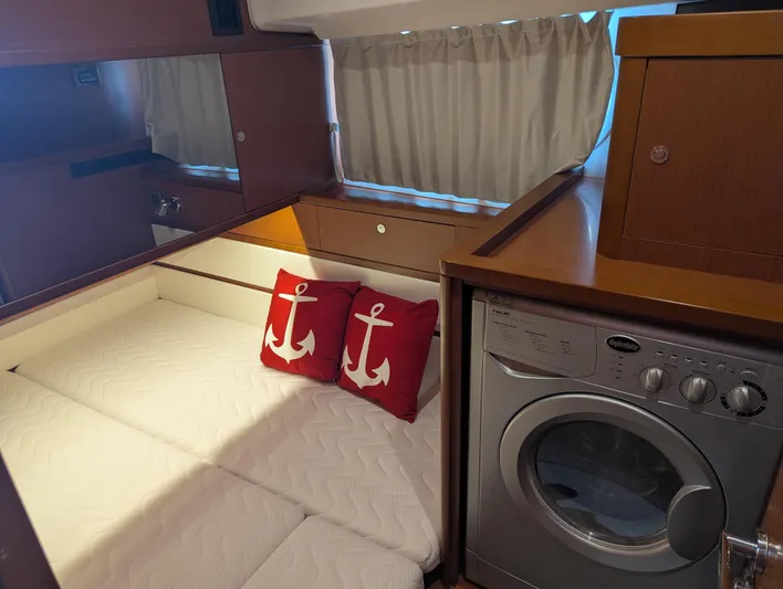  Yacht Photos Pics Cozy cabin interior of 2019 Beneteau Swift Trawler 44 with bed, anchor pillows, and washing machine.