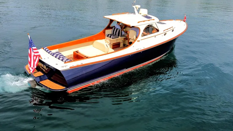 Luna Yacht Photos Pics Hinckley Picnic Boat 2000 cruising on water, featuring elegant design and American flag.