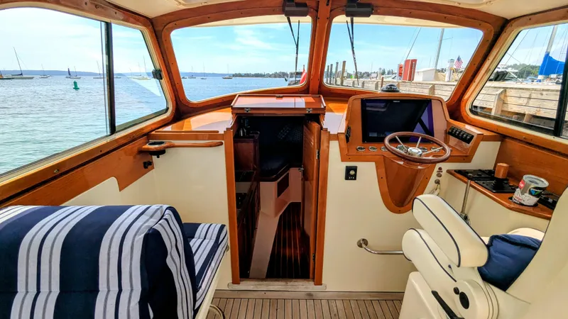 Luna Yacht Photos Pics Interior of a 2000 Hinckley Picnic Boat with striped seating and wooden helm.