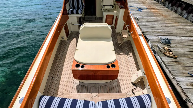 Luna Yacht Photos Pics 2000 Hinckley Picnic Boat interior with striped seating, dockside view, and wooden deck.