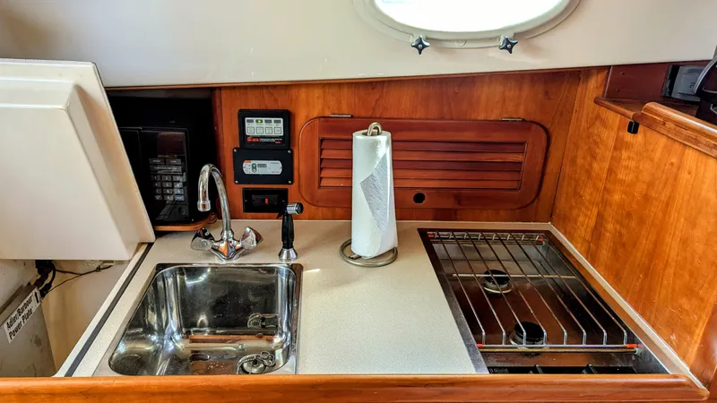 Luna Yacht Photos Pics Compact galley in 2000 Hinckley Picnic Boat with sink, stove, and paper towel holder.