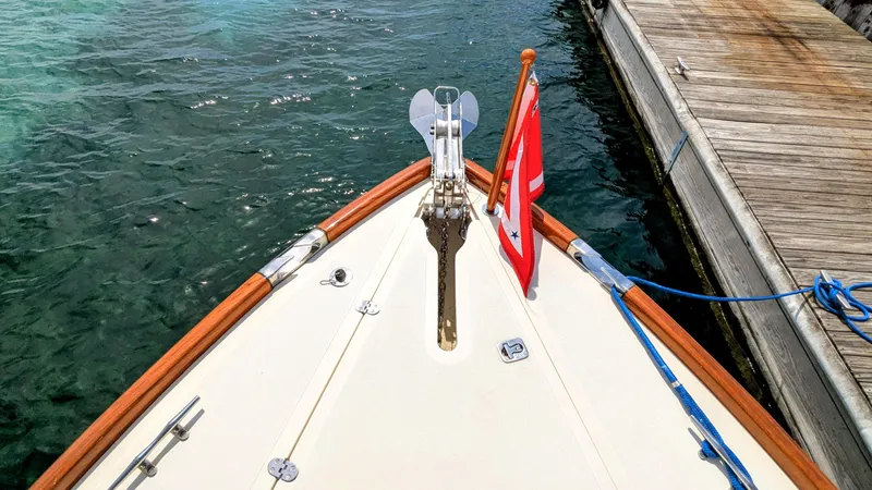 Luna Yacht Photos Pics Bow of a 2000 Hinckley Picnic Boat docked, featuring a flag and anchor chain.