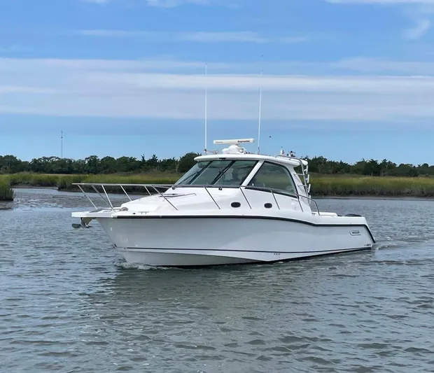 Reel Inspired Yacht Photos Pics 2009 Boston Whaler 345 Conquest boat on calm water under blue sky.