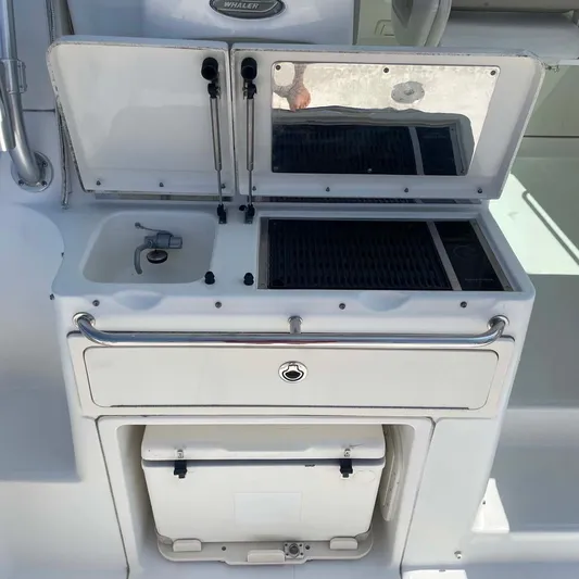 Reel Inspired Yacht Photos Pics 2009 Boston Whaler 345 Conquest boat galley with sink and storage compartments.