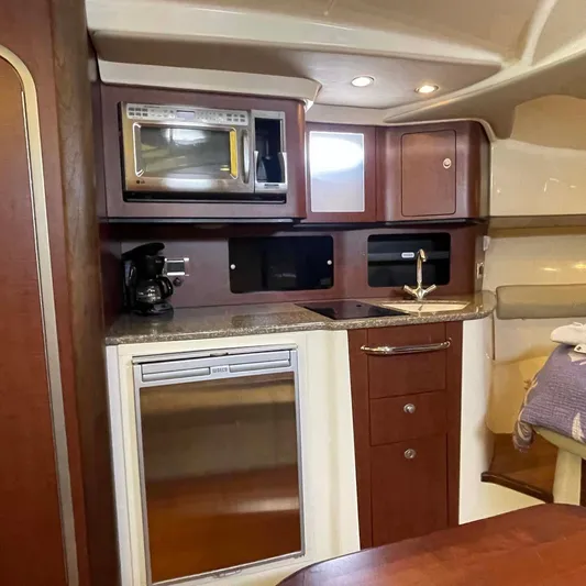 Reel Inspired Yacht Photos Pics 2009 Boston Whaler 345 Conquest interior kitchen with microwave, sink, and fridge.