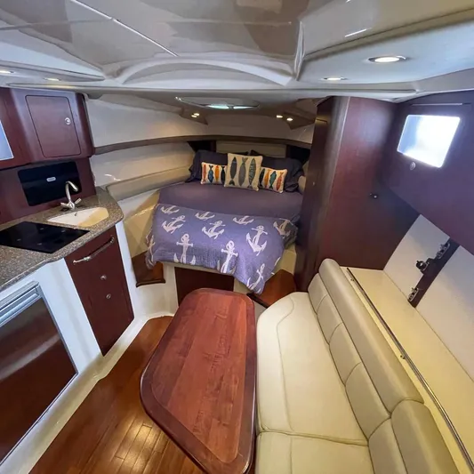 Reel Inspired Yacht Photos Pics 2009 Boston Whaler 345 Conquest cabin interior with bed, kitchenette, and seating area.