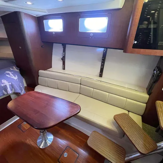 Reel Inspired Yacht Photos Pics Interior of 2009 Boston Whaler 345 Conquest with seating and wooden table.