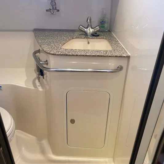 Reel Inspired Yacht Photos Pics 2009 Boston Whaler 345 Conquest bathroom with sink, granite countertop, and storage cabinet.