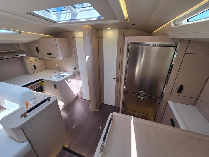 Yachting Conseil Yacht Photos Pics Luxurious interior of 2023 Jeanneau 60 yacht, featuring modern kitchen and sleek design.